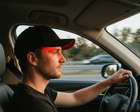 Man wearing Luxuel Laser Cap 128 while driving