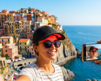 Woman taking selfie with Luxuel Laser Cap 128 while travelling
