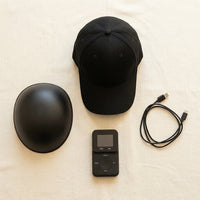 What ships with the Luxuel Laser Cap 132, laid out on linen: the cap, the removable dome insert, the handheld controller and the USB power cable