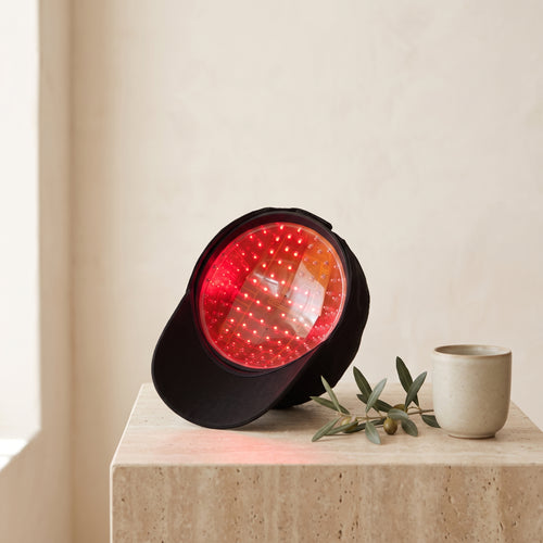 Luxuel Laser Cap 128 tilted to reveal 128 glowing red 650nm laser diodes inside